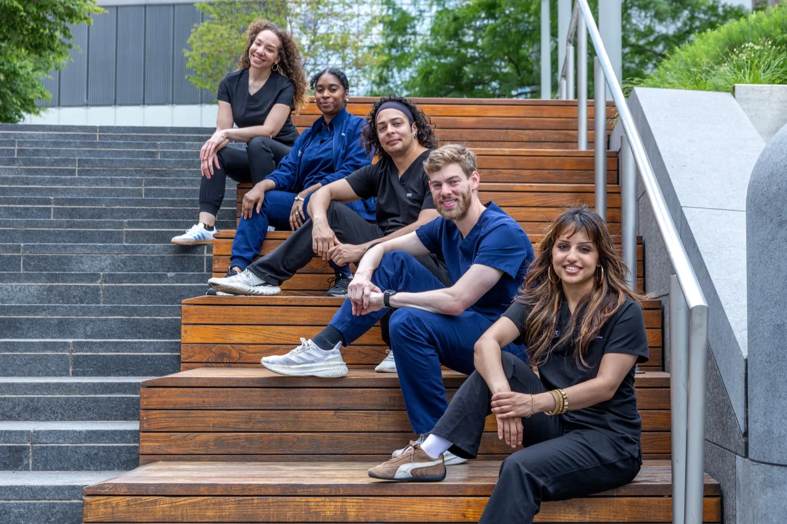 Wall Street Orthodontics team sitting on wooden steps in Lower Manhattan
