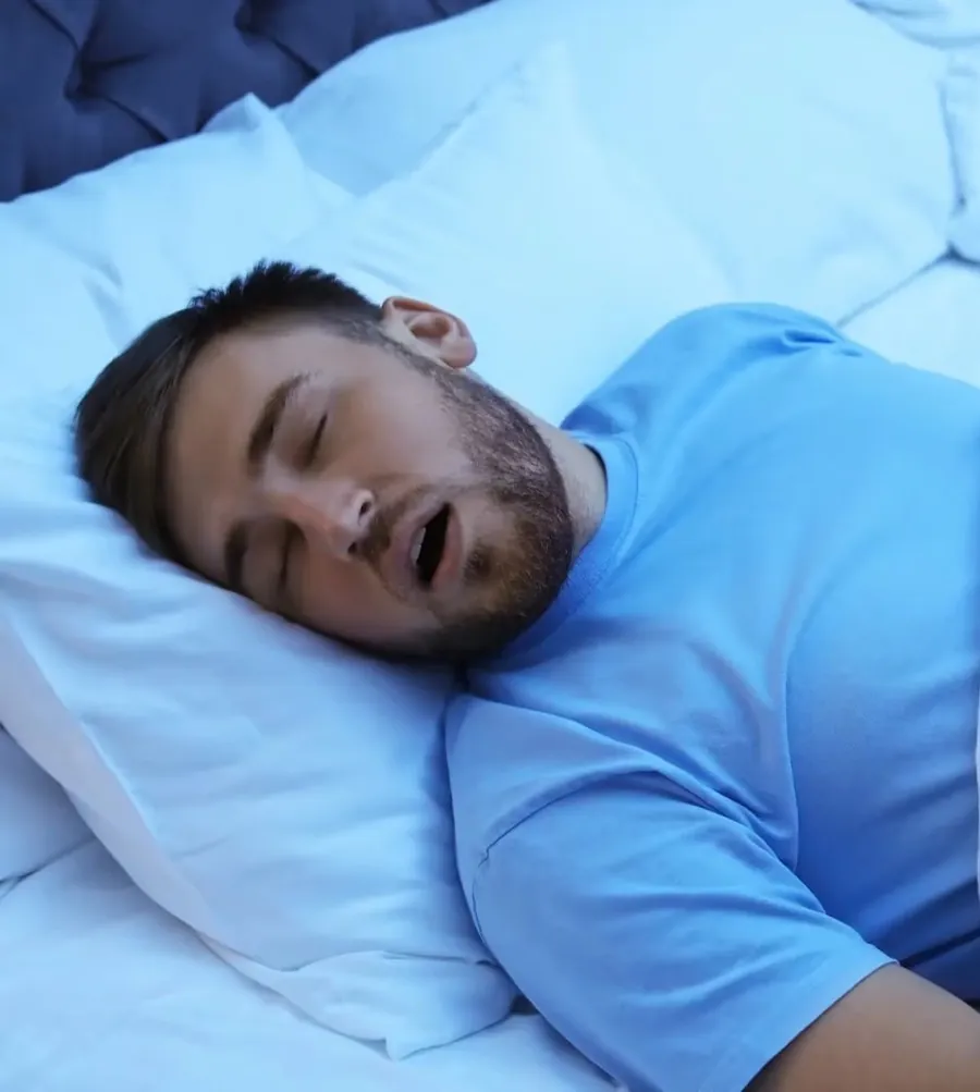 A man asleep on his back with his mouth open